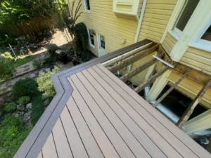 Partially finished gray composite deck built around a raised home entrance
