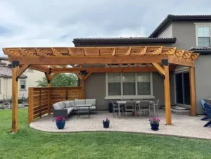 Wood pergola shelter covering a backyard patio and seating area