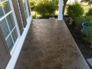 Stamped concrete covered porch floor beside white exterior doors