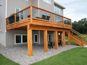 Elevated natural wood deck on posts with black balusters and a long staircase