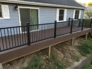 Long elevated brown deck with black railings along a gray single-story home