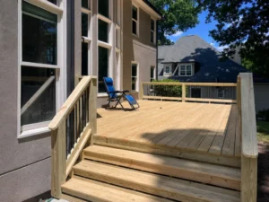 New natural wood deck with wide stairs and unfinished wood railings