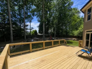 Expansive new natural wood deck overlooking a wooded backyard